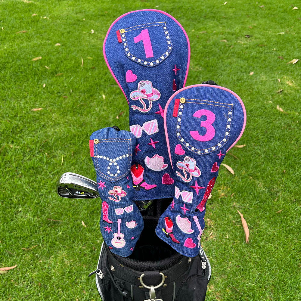 Three western golf club head covers with decorative denim rhinestone cowgirl patterns on a grass background