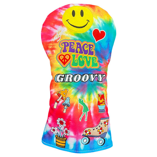 A tie-dye driver golf club headcover featuring a yellow smiley face, a red heart, the words 'PEACE LOVE GROOVY' in colorful retro lettering, and small retro illustrations including mushrooms, a frog, flowers, and roller skates on a white background.