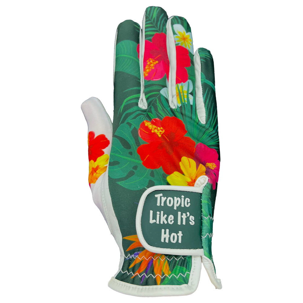 Women's golf glove with tropical floral design and 'Tropic Like It's Hot' text on the strap, on a white background. Worn on right hand.