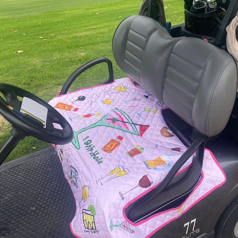 Pink 19th Hole cocktail print golf cart seat blanket and cover installed on a cart seat.