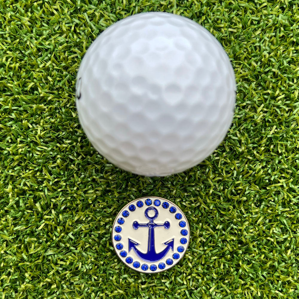 Golf ball on a green grass surface with a blue anchor ball marker.