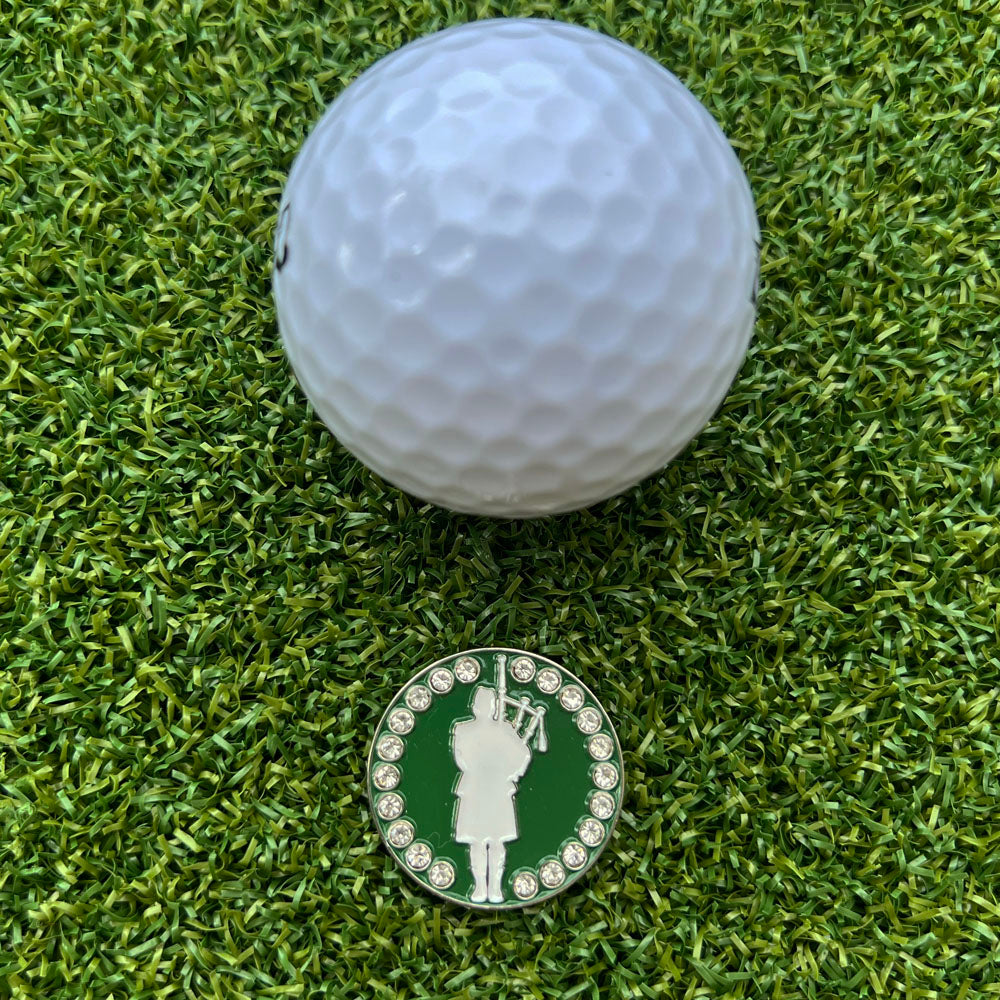 Golf ball and golf marker with bagpiper design on grass
