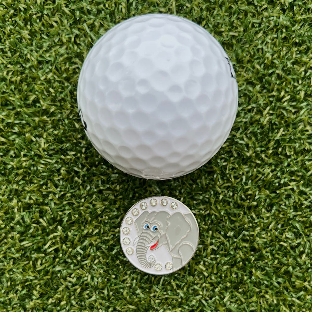 elephant themed ball marker with white golf ball on grass
