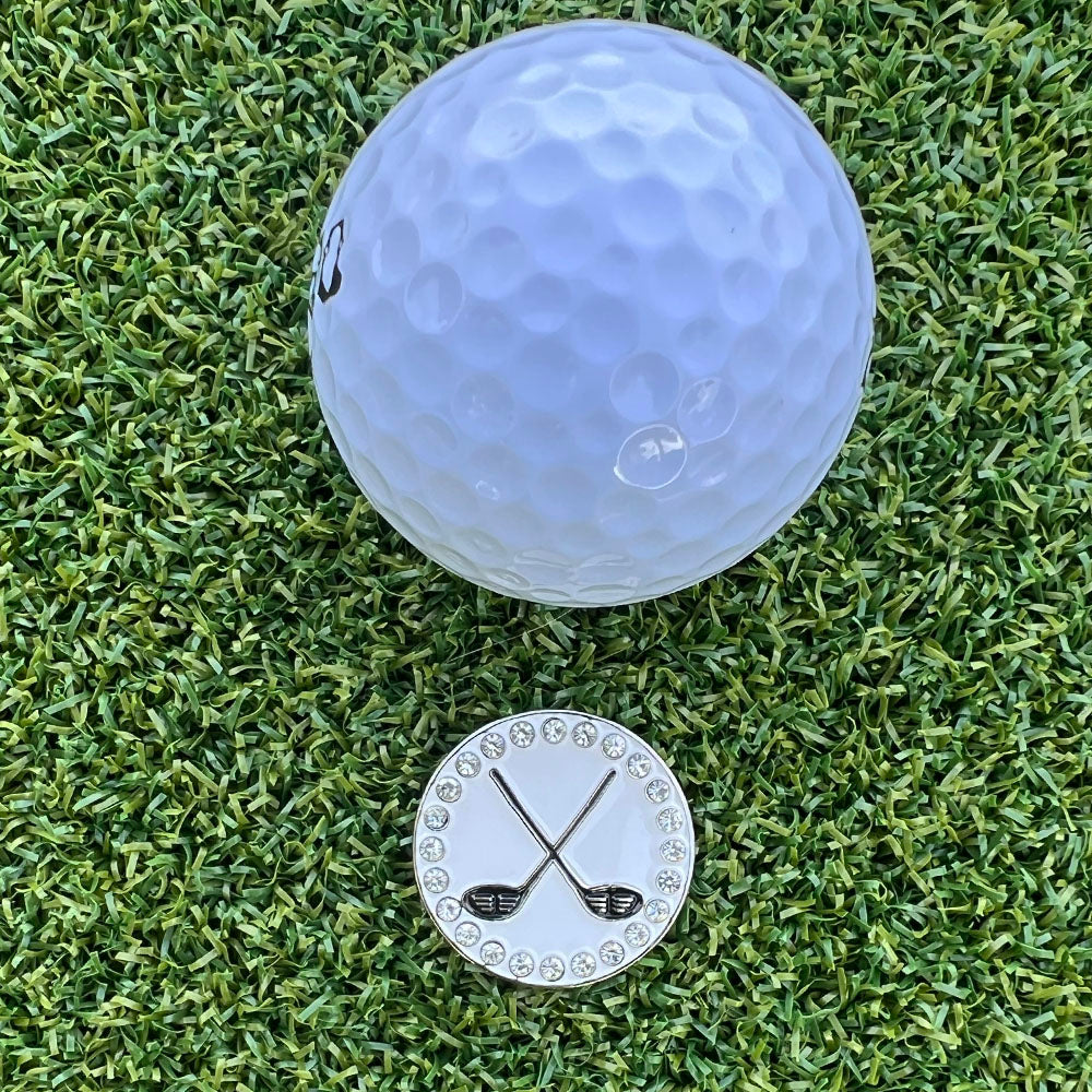 Golf ball and crossed golf clubs marker on grass