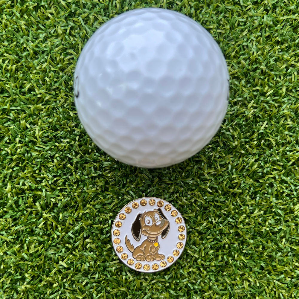 Golf ball with a dog-themed marker on a grassy surface