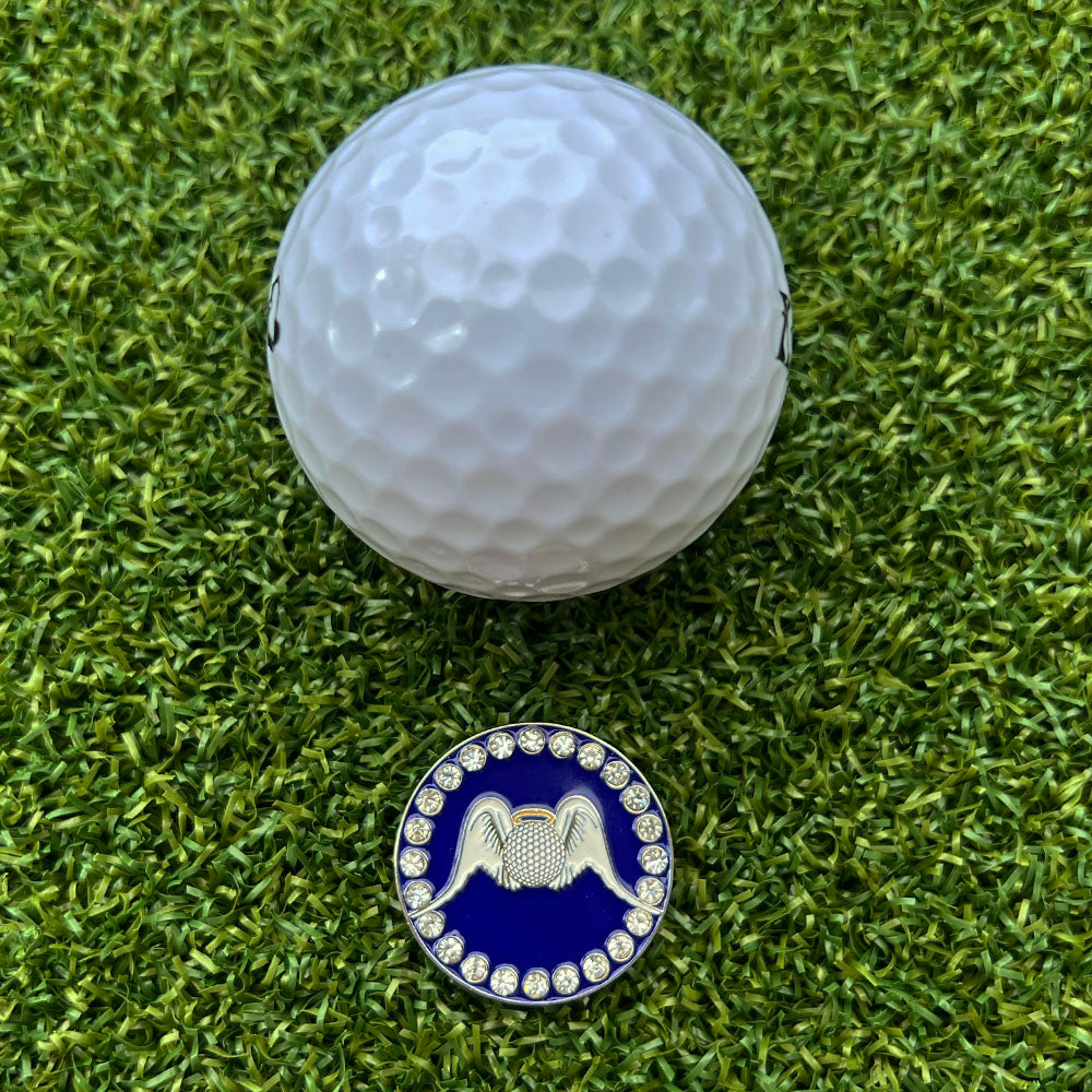Golf ball and blue ball marker with angel wings and halo design on grass