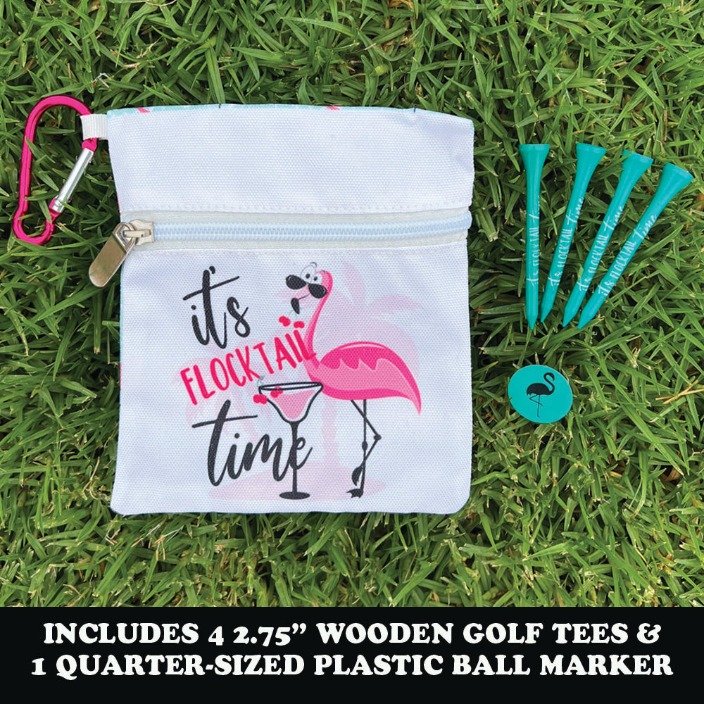 Golf bag with flamingo design, teal golf tees, and ball marker on grass
