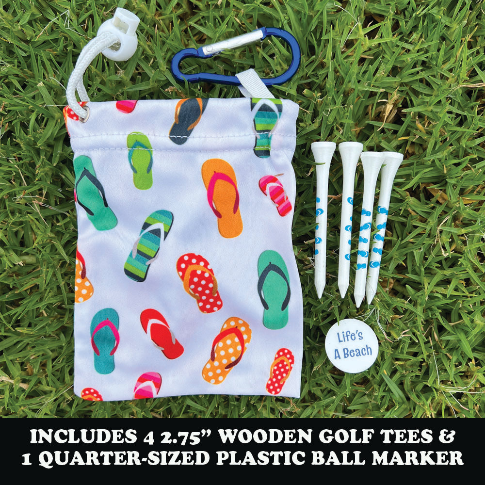 Colorful flip-flop patterned drawstring bag with golf tees and a ball marker on grass.