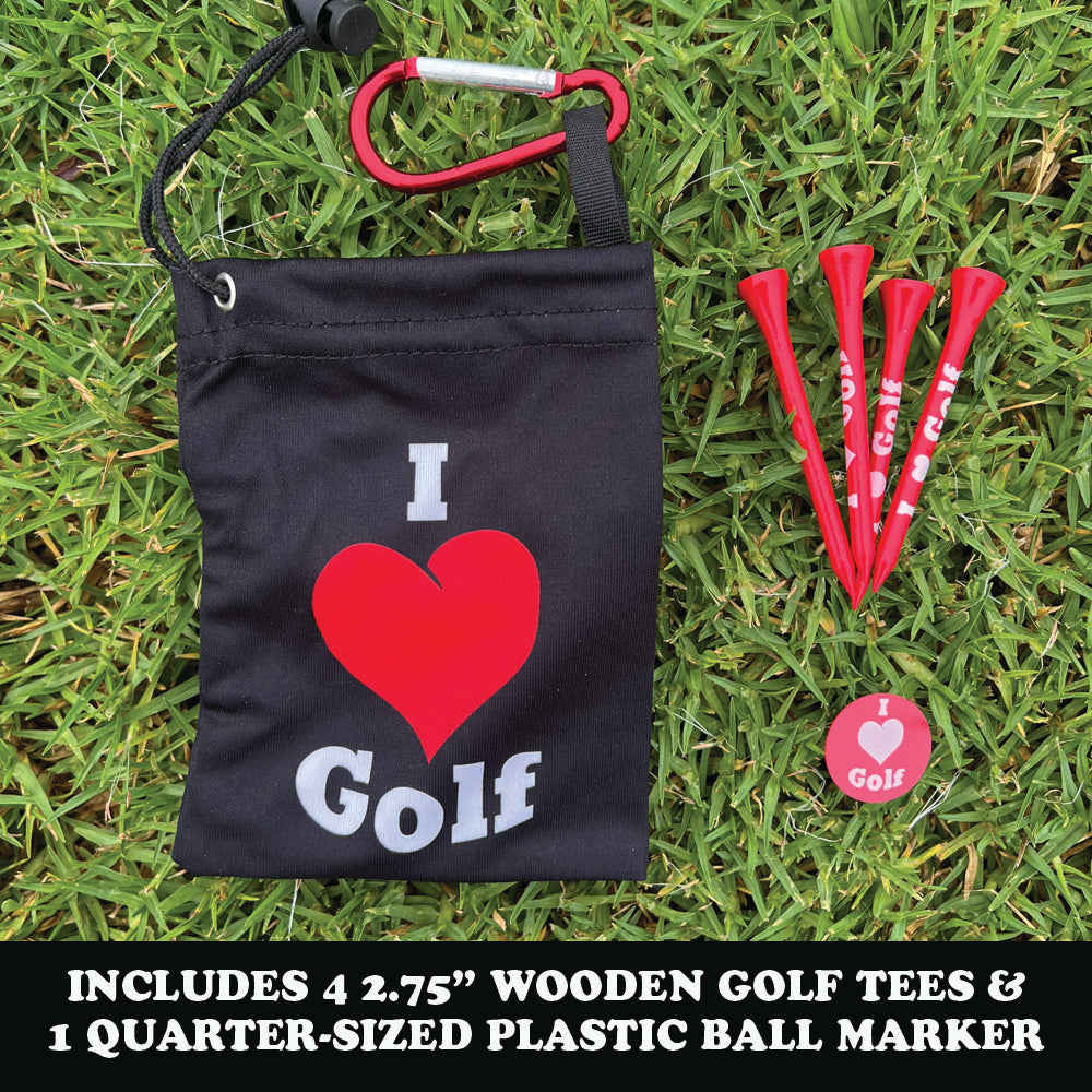 Black bag with 'I ❤️ Golf' text, red carabiner, red golf tees, and red ball marker on grass.