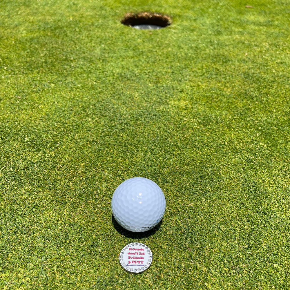 Giggle Golf Bling Friends don’t let friends 3 putt On A Putting Green, Behind A White Golf Ball