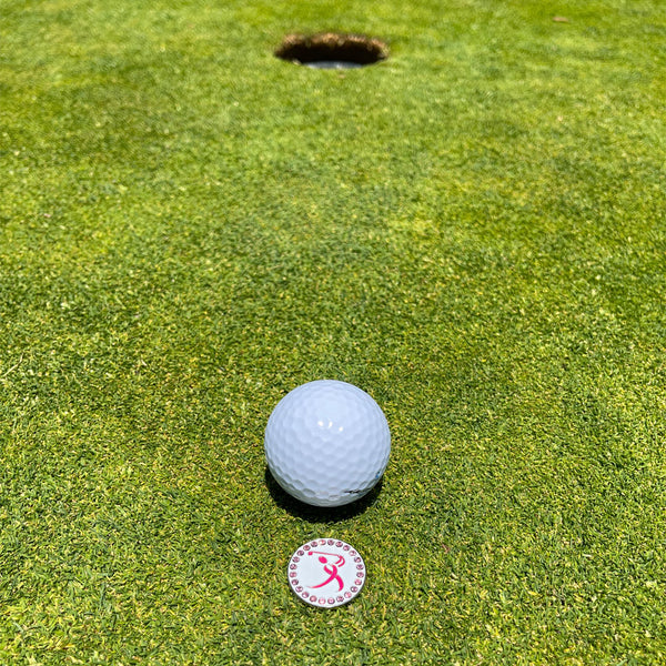 Giggle Golf Bling Breast Cancer Pink Ribbon Golfer Ball Marker On The Putting Green, Behind A White Golf Ball
