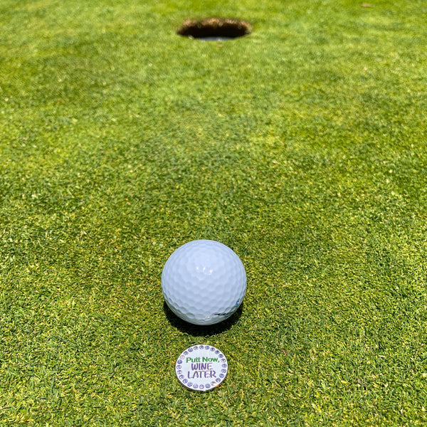 Giggle Golf Bling Putt Now Wine Later Ball Marker On Putting Green, Behind A Golf Ball