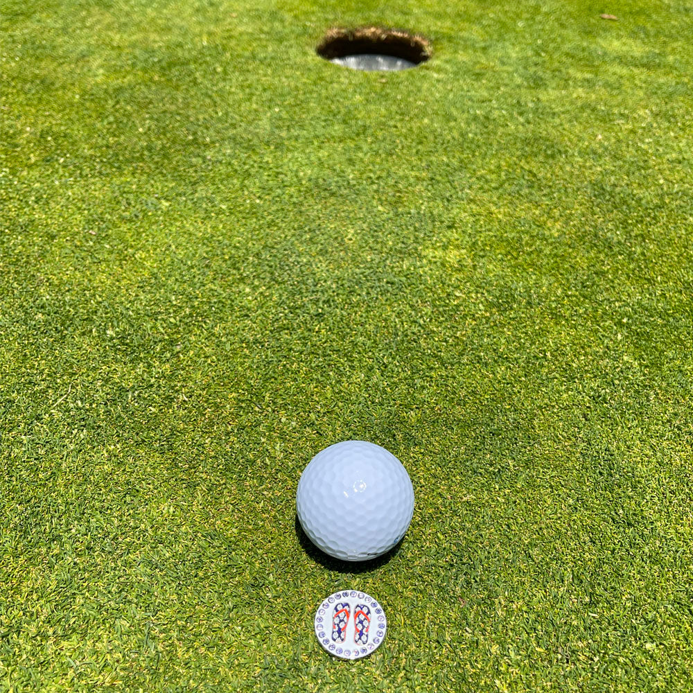 Giggle Golf Bling Purple Flip Flops On A Putting Green, Behind A White Golf Ball