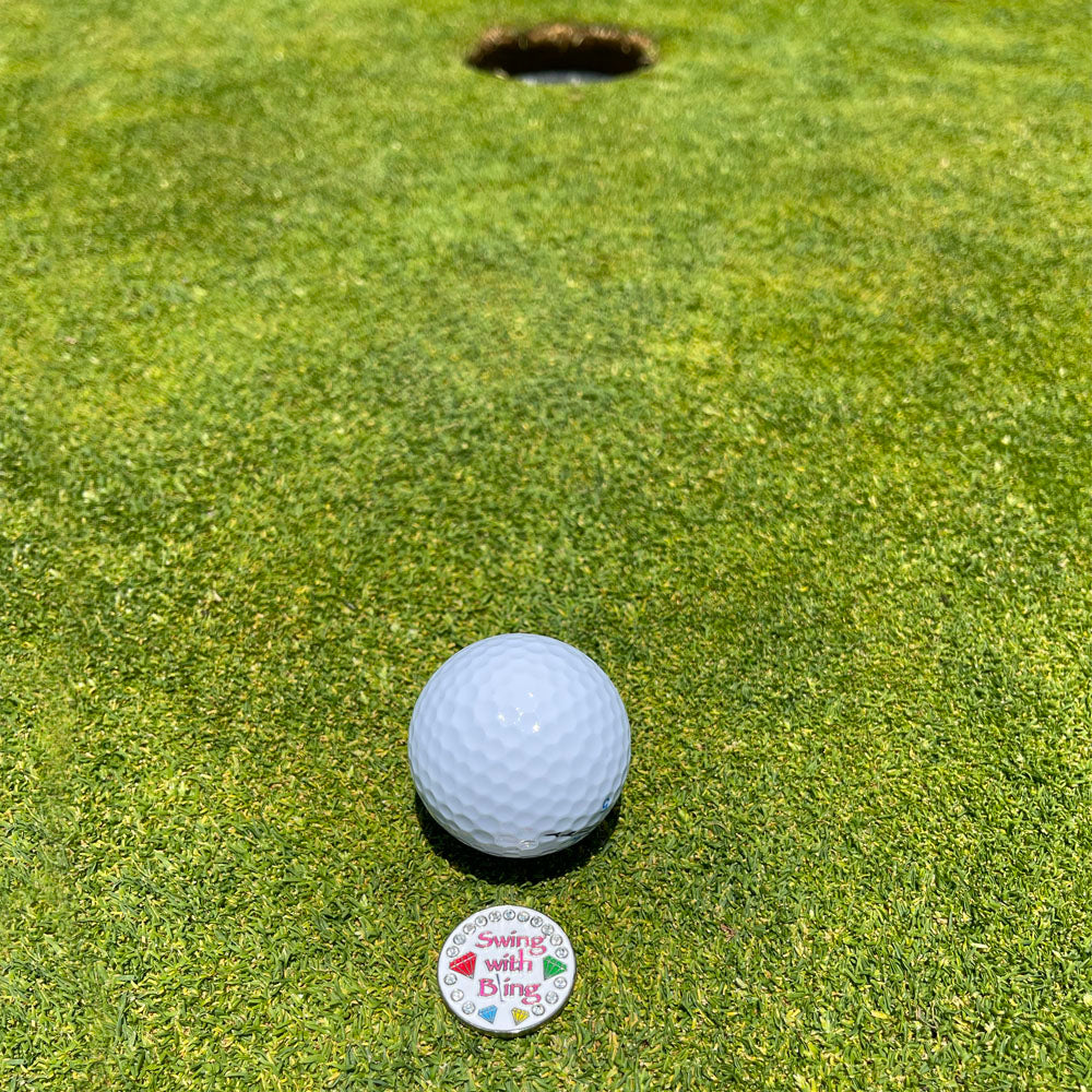 Giggle Golf Bling Swing With Bling (White) Ball Marker On A Putting Green, Behind A White Golf Ball