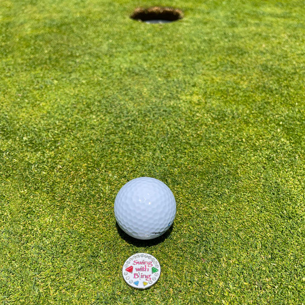 Giggle Golf Bling Swing With Bling (White) Ball Marker On A Putting Green, Behind A White Golf Ball