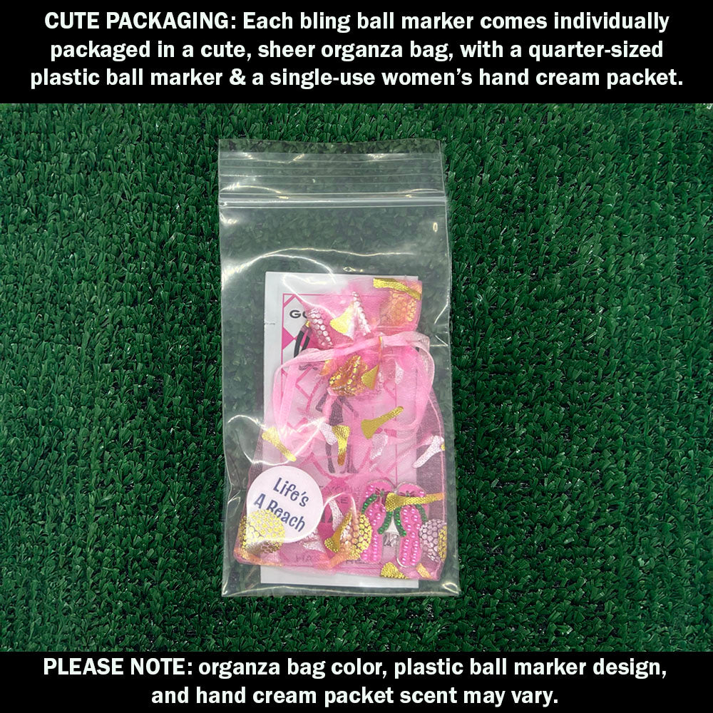 Cute packaging with bling pink flip flops ball marker, plastic ball marker, and hand cream packet on a green textured background.