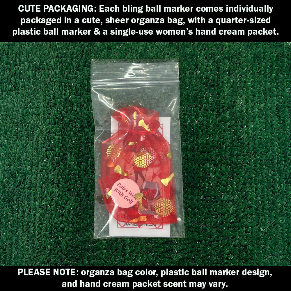 Cute packaging with bling red wine ball marker, plastic ball marker, and hand cream packet on a green textured background.