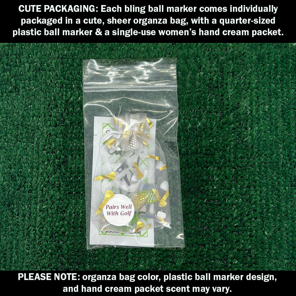 Cute packaging with bling white wine ball marker, plastic ball marker, and hand cream packet on a green textured background.