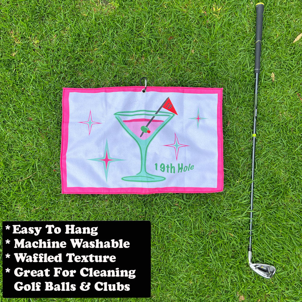 Golf towel with '19th Hole' design and golf club on grass, featuring text about towel properties.
