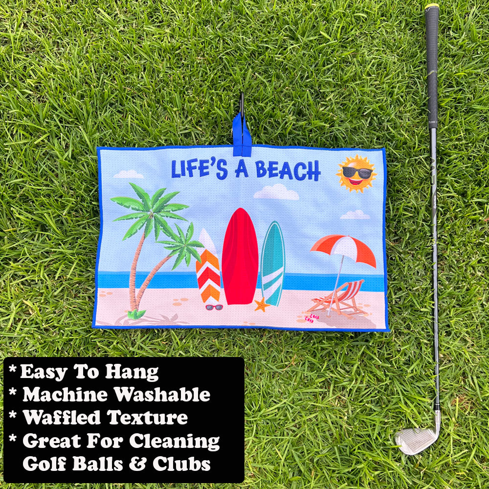 Life's A Beach golf towel on grass with a golf club and text