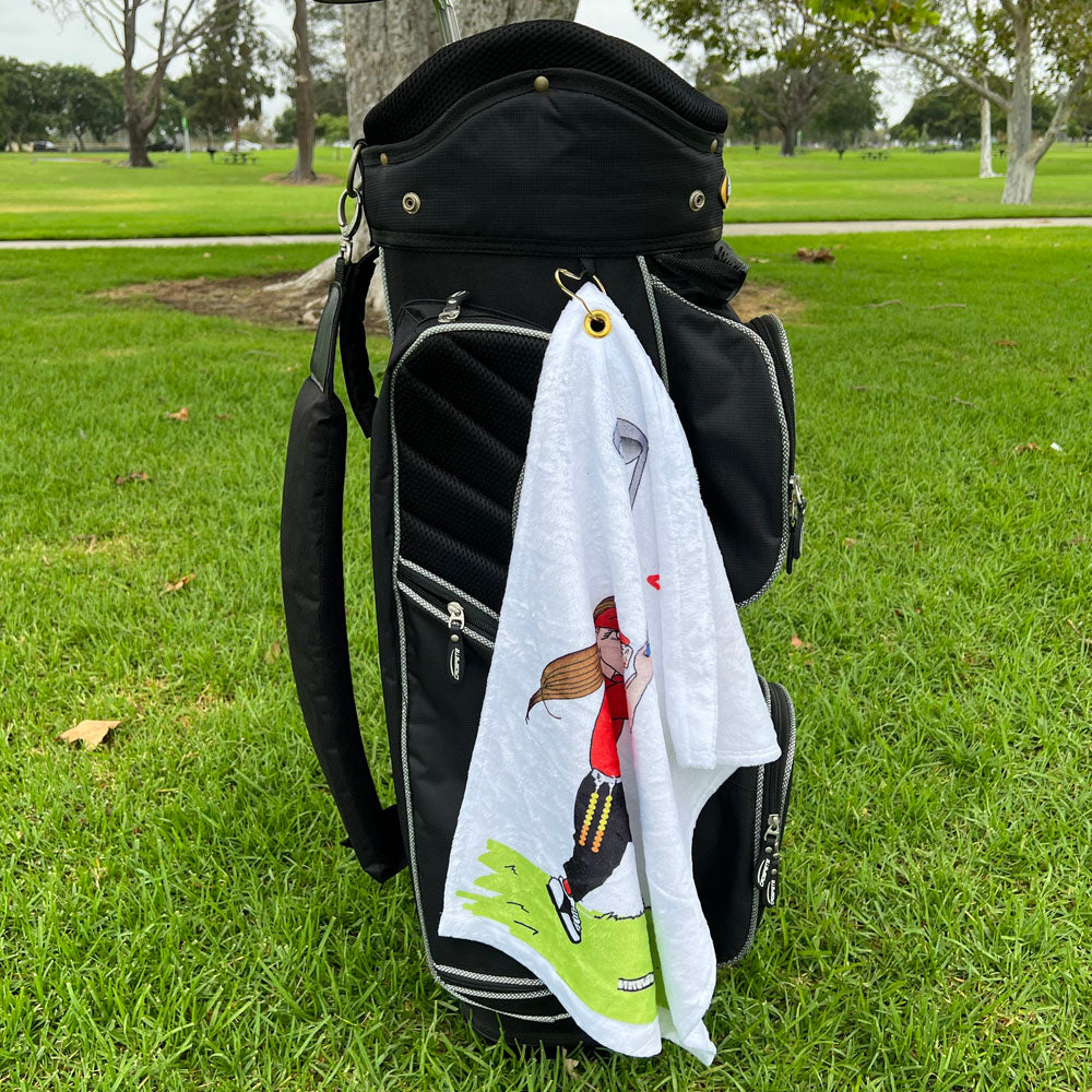 Golf bag with a towel featuring a female golfer with stroke beads design on a grassy background
