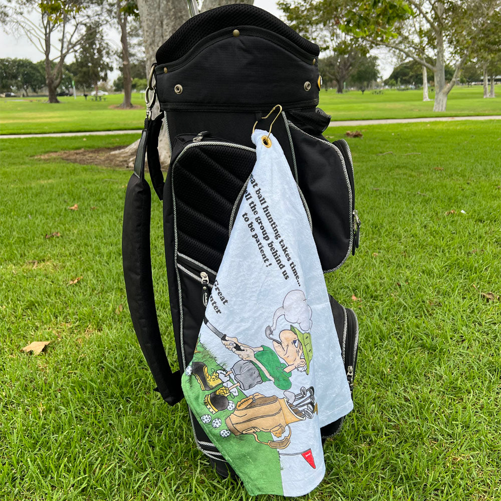 Golf bag with a towel featuring a male golfer cartoon character on a grassy background