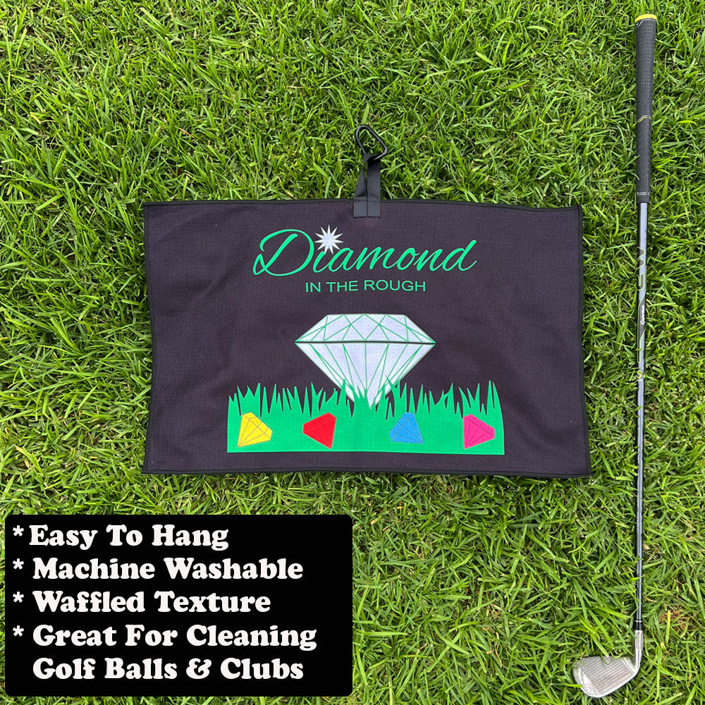 Golf towel with 'Diamond in the Rough' design on grass with golf club
