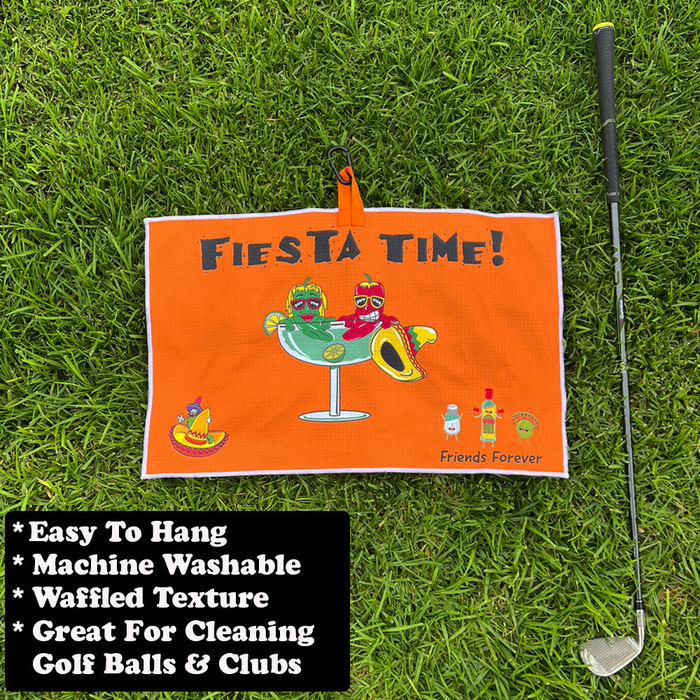 Orange towel with 'Fiesta Time!' text and graphics on grass next to a golf club.