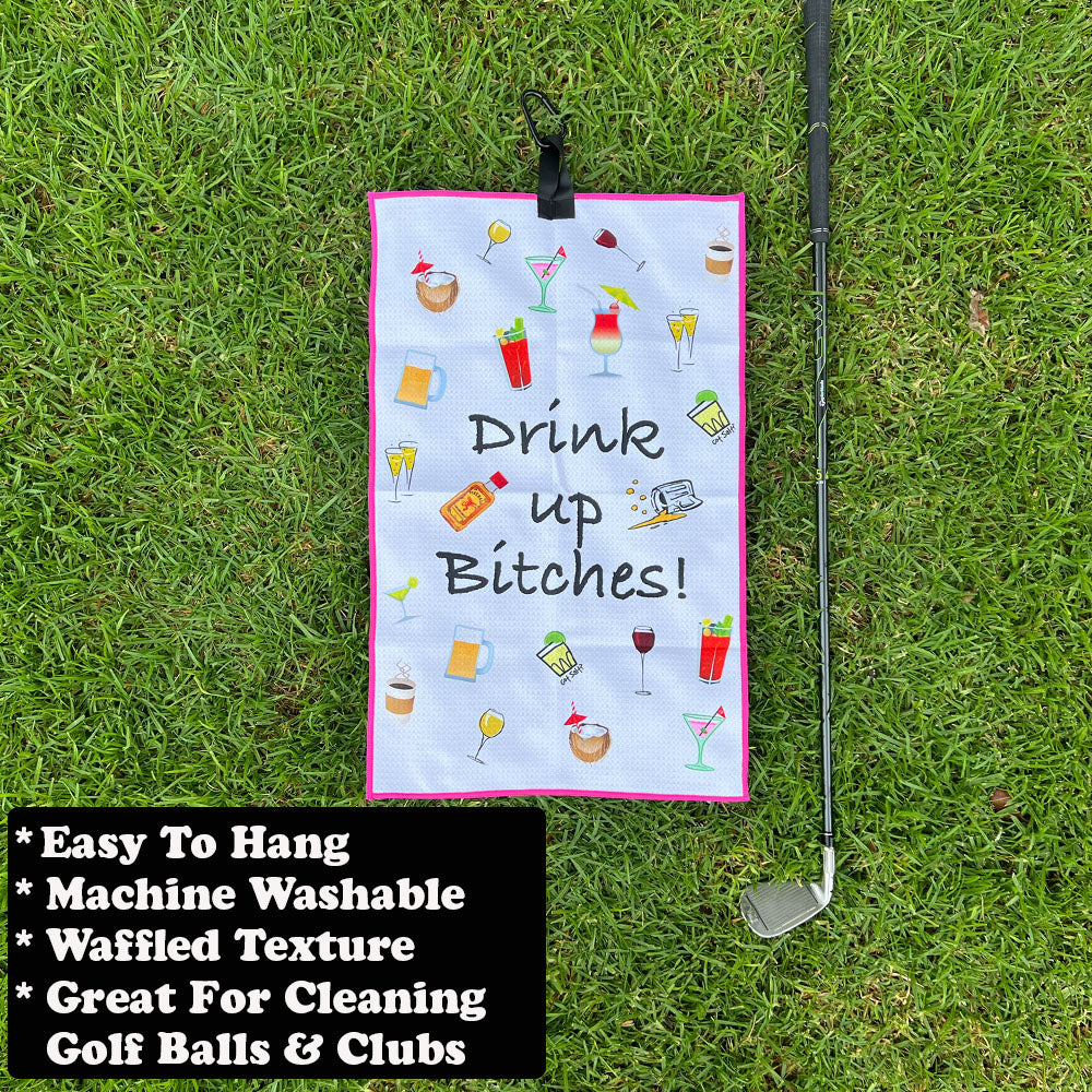 Golf towel with humorous design on grass next to a golf club