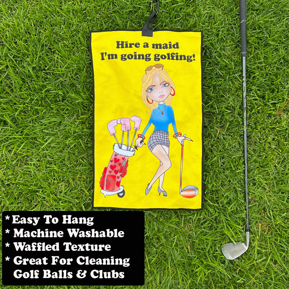 Yellow golf towel with female cartoon golfer next to a golf club on grass