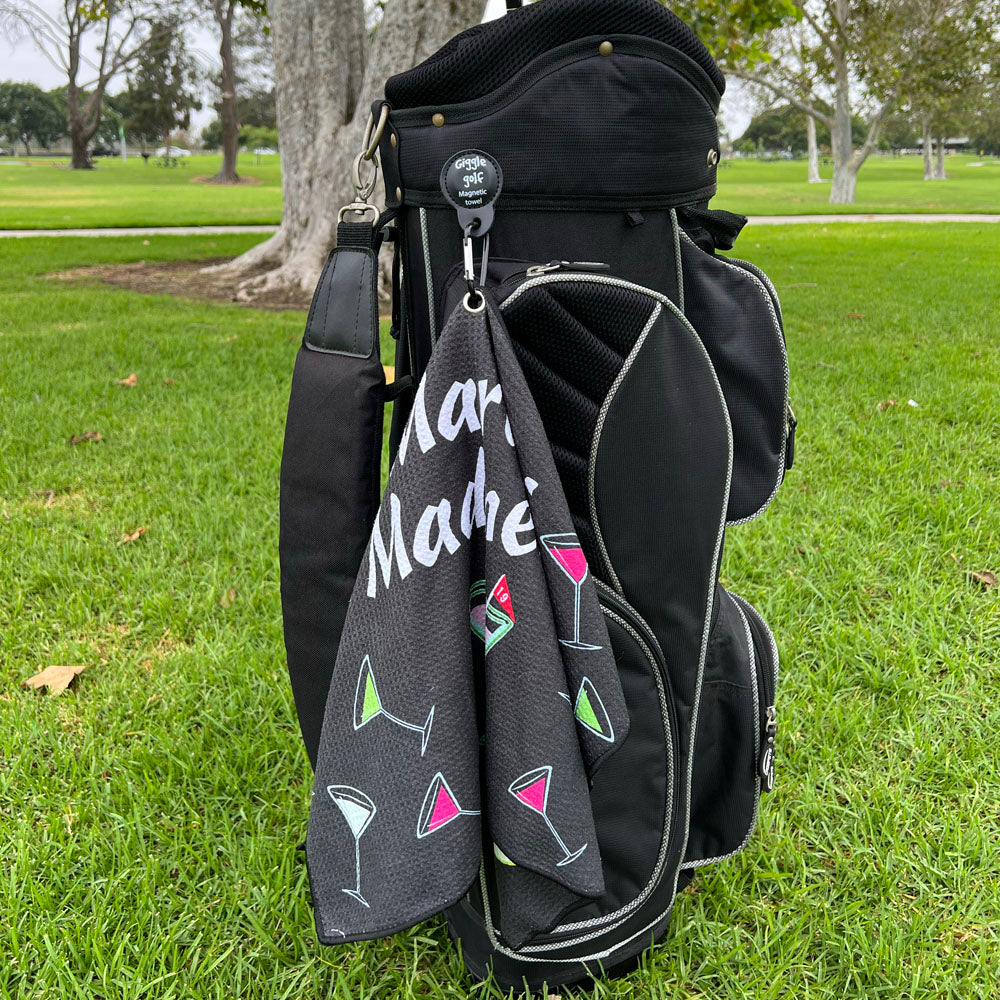 black golf towel with colorful martinis attached to a golf bag with magnetic clip