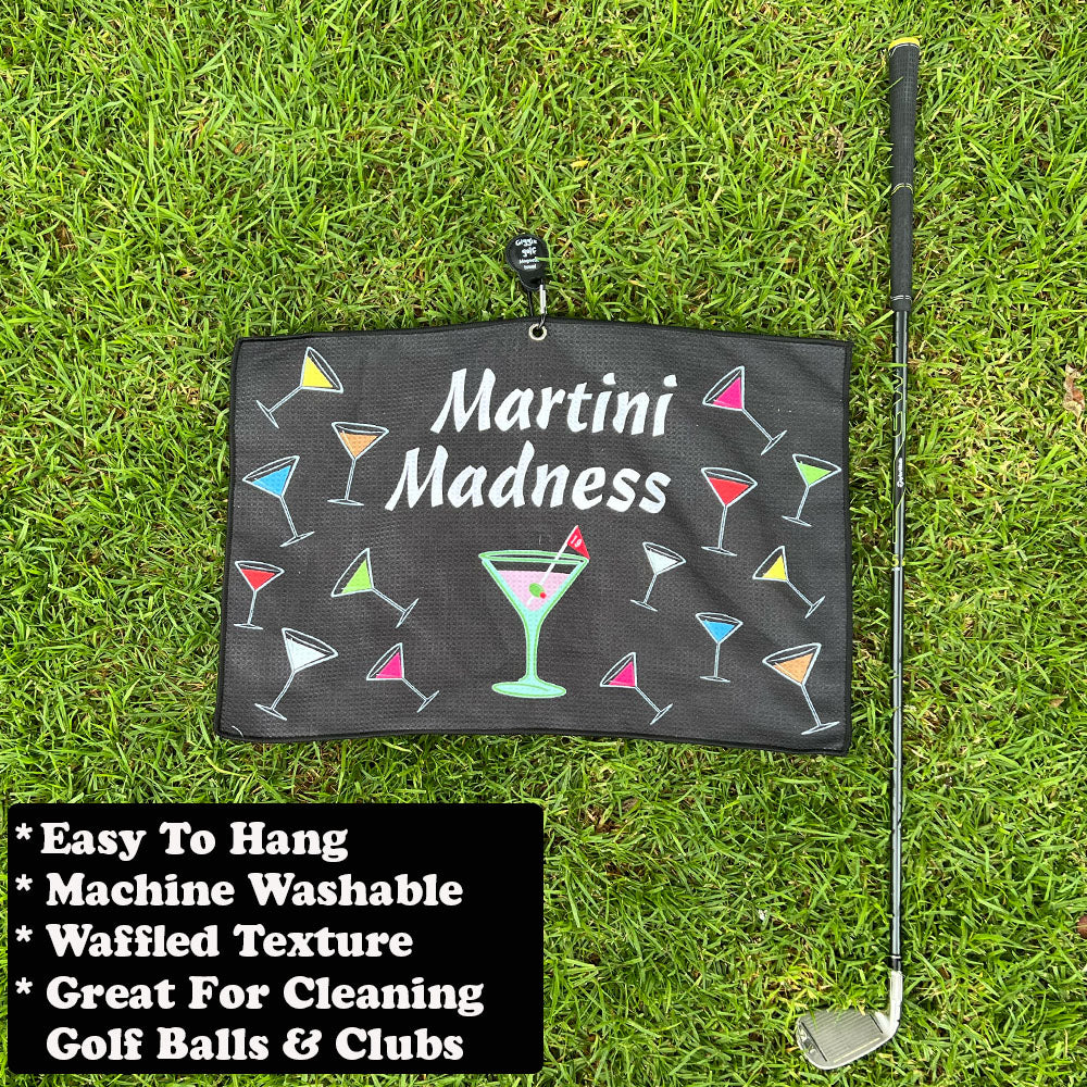 Golf towel with 'Martini Madness' design on grass with golf club