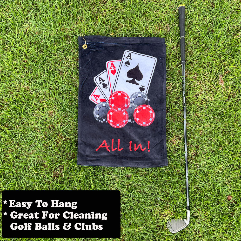 black golf towel with playing cards and poker chip design, next to a golf club, on grass