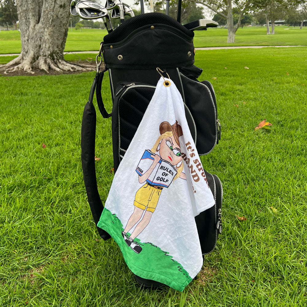 Golf towel with cartoon golfer character on a golf bag in a grassy area