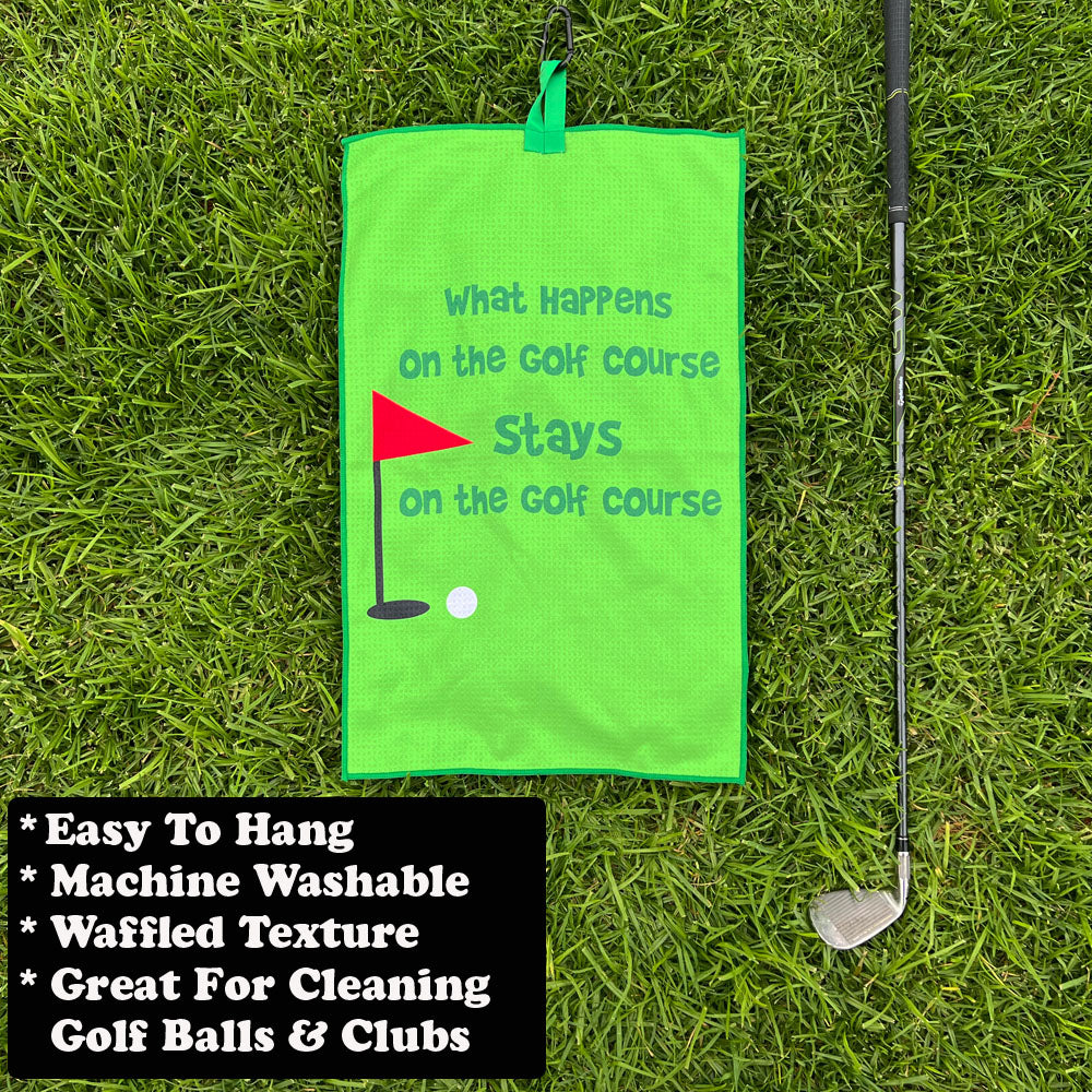 Green funny golf towel with text on grass, next to a golf club