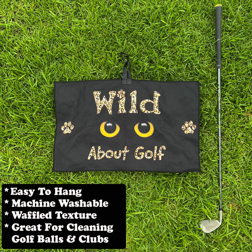 Golf towel with 'Wild About Golf' text on grass with golf club