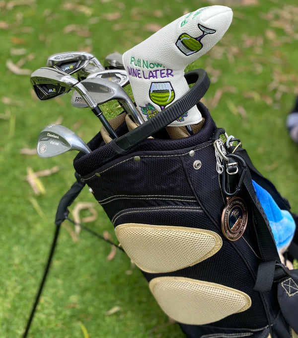putt now wine later side 1 blade putter cover in a golf bag